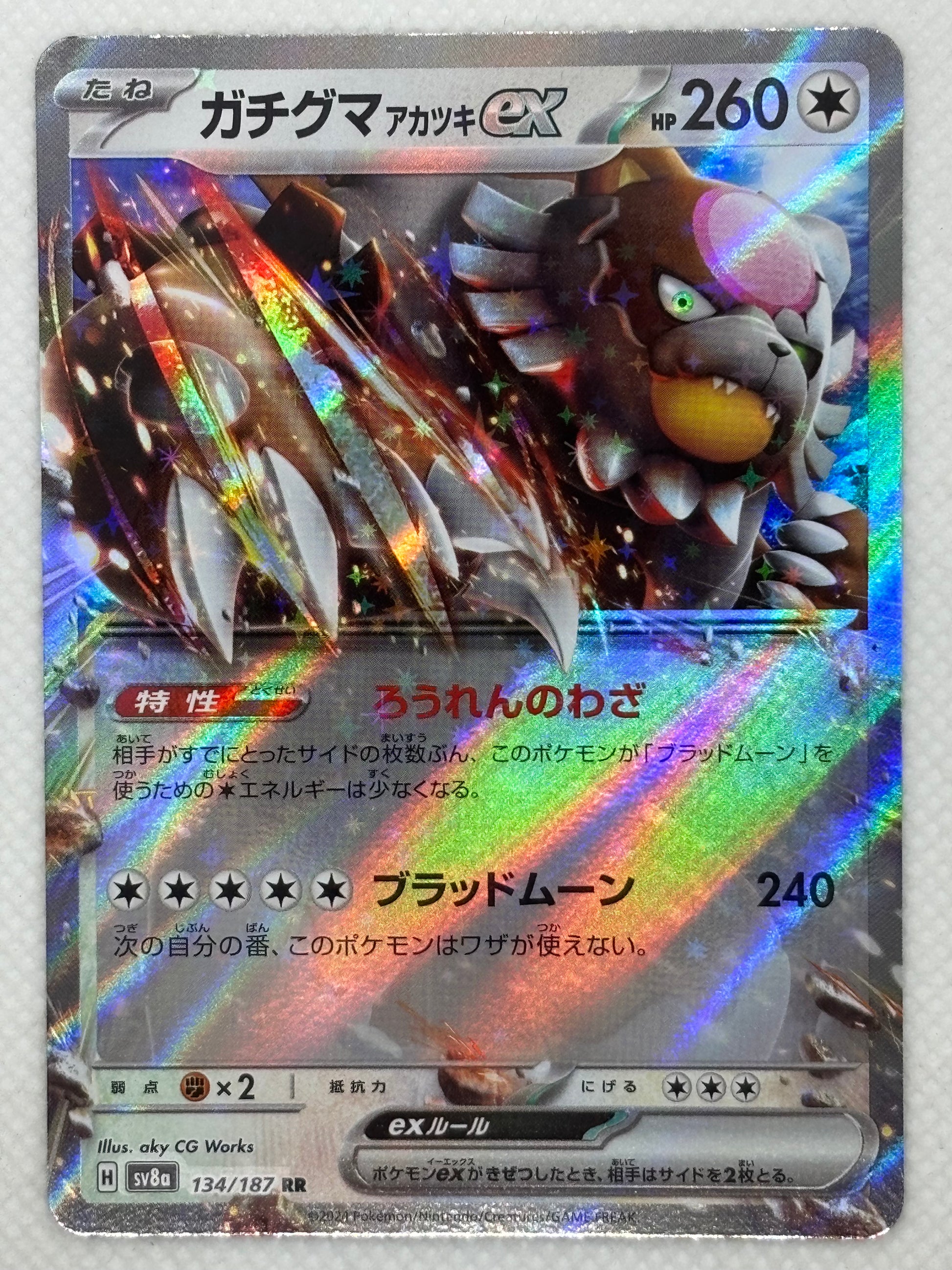 Bloodmoon Ursaking ex card showing its details, abilities, and its role in the Terastal Festival ex set of the Scarlet & Violet series.