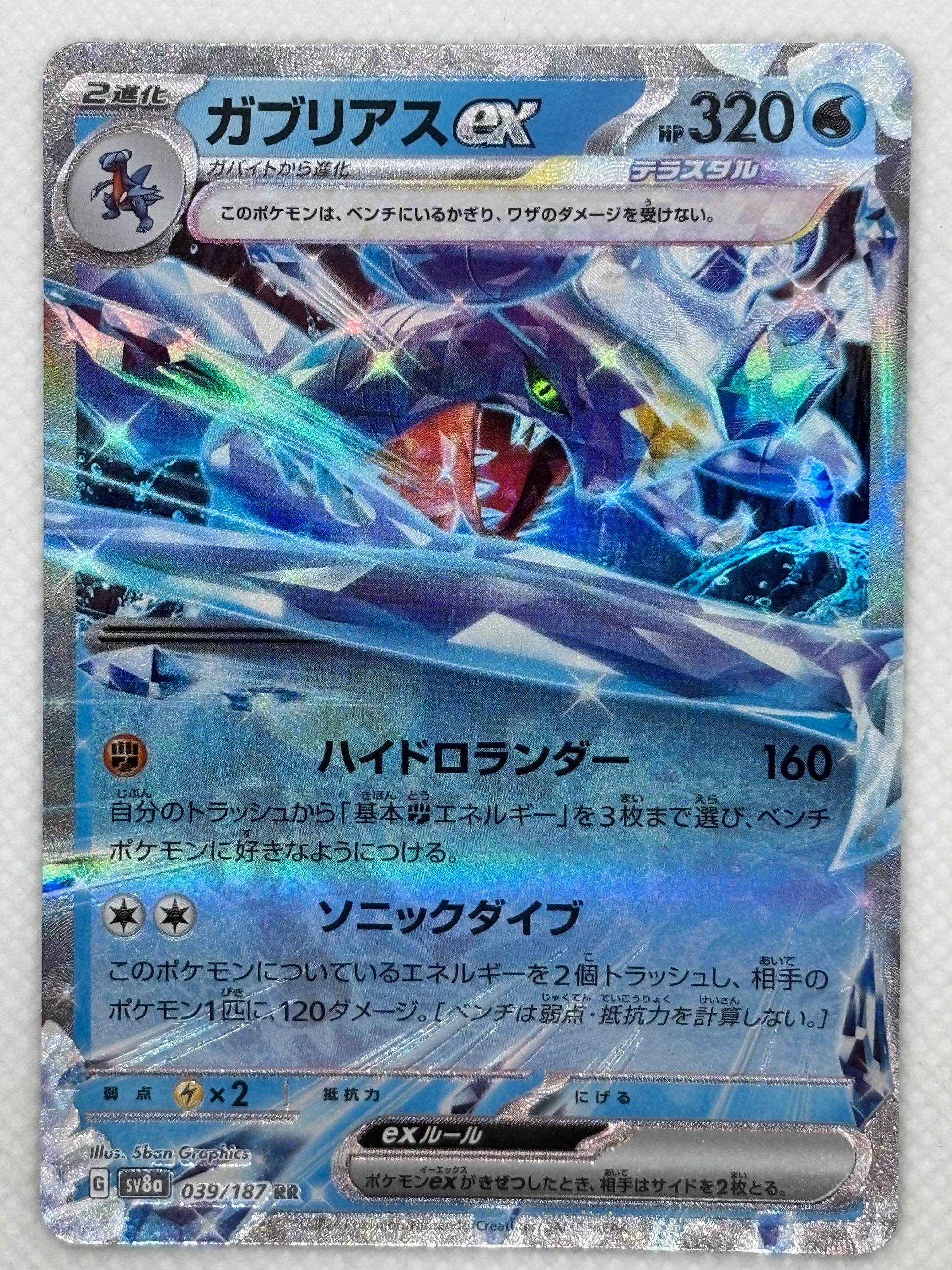 Garchomp ex card showing its details, abilities, and its role in the Terastal Festival ex set of the Scarlet & Violet series.